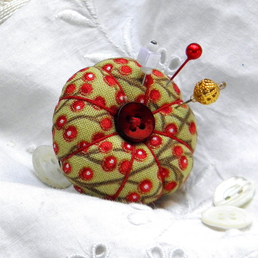Pincushion ring in festive red berries design with a red button.