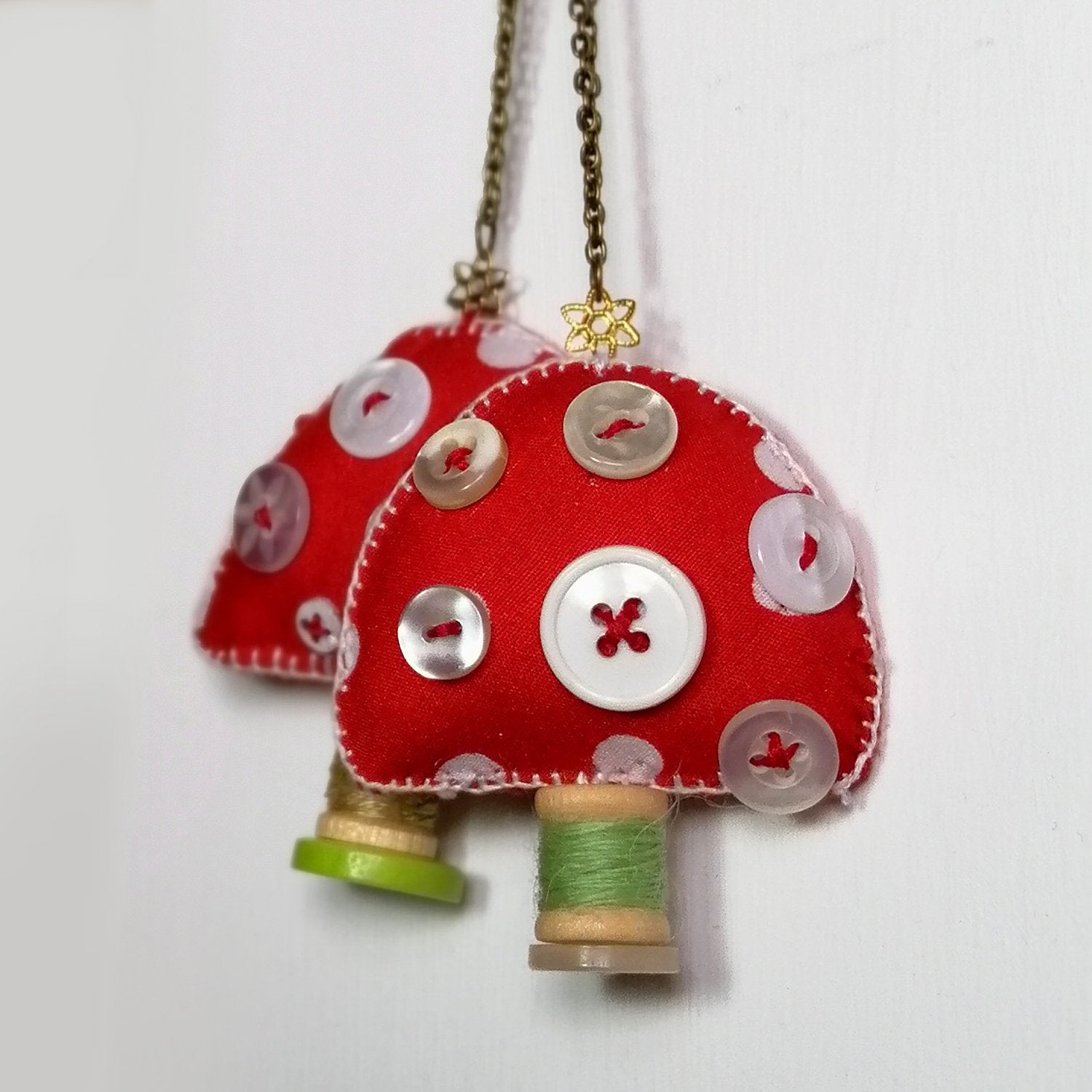 Red Fabric toadstool ornament with white spots, buttons and wooden spool.
